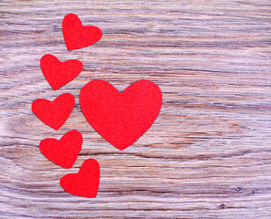 Red hearts on a wooden background. Paper hearts.