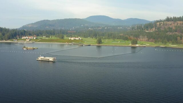 Aerial Coeur d'Alene Idaho resort boat on lake going past golf course