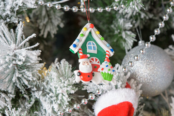 New Year concept. House toy and Santa Claus hanging, decorative Christmas tree cup