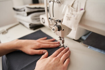 Woman seamstress sitting and sews