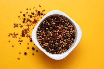 Black pepper in white bowl on brown wood background with copy space. Healthy eating, ayurveda, naturopathy concept