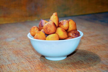 Sugar palm fritters or taler bora in a white bowl on wooden back