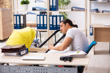 Young male employee looking after newborn at workplace