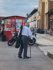 señor caminado con una guitarra por la calle