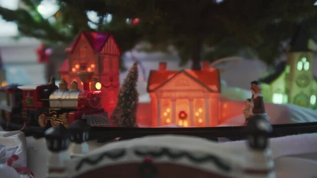 Toy Steam Train rolls underneath Christmas Tree and tiny toy town
