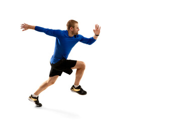 Fototapeta na wymiar Energy. Caucasian professional jogger, runner training isolated on white studio background. Muscular, sportive man, emotional. Concept of action, motion, youth, healthy lifestyle. Copyspace for ad.