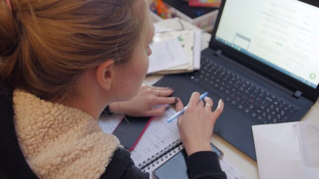 Accountant working at the computer woman at the table with laptop and documents top back view closeup