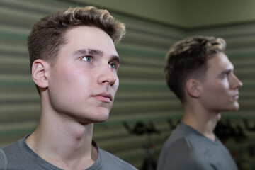 Young athlete men and his reflection in the gym