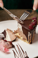 Woman eating chocolate cake with raspberry