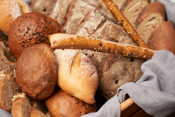 Basket with fresh bread on wooden table background