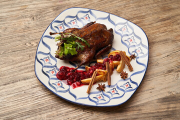 Roasted duck with quince on wooden table background