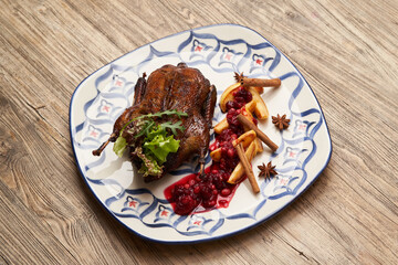 Roasted duck with quince on wooden table background