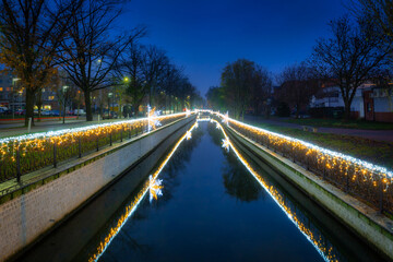 Christmas lights over the Radunia canal in Pruszcz Gdanski at dusk, Poland.