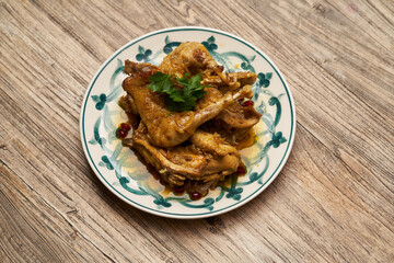 Fried chicken legs with pomegranate and parsley on wood table