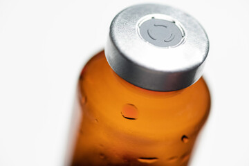 Macro Shot Of Amber Vaccine Vial In White Background