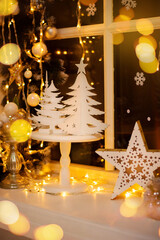 Decoration and christmas concept. Christmas decoration on the window sill. White Christmas. Gold bokeh.
