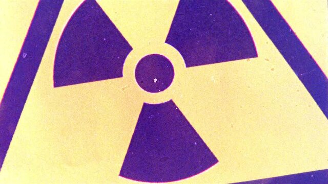 Grainy cross-processed 16mm film footage of a radiation warning sign