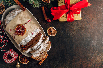 Christmas Stollen. Traditional Sweet Fruit Loaf with Icing Sugar on wooden table. Christmas festive table setting.
