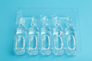 Medical ampoules with a vaccine on a blue background. Medicine for disease or medicine for health concept.