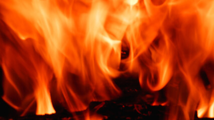 Abstract fire flame in fireplace, texture for background. Beautiful bright orange flames flicker in the darkness of the night.