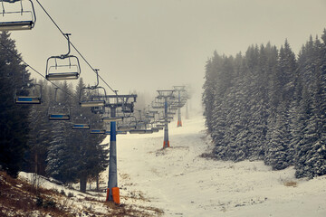 Ski lift on foggy day. Without enough snow this ski lift must stop.