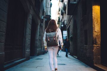 Trendy female student walking along street