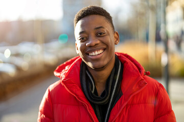 Portrait of a young man standing in a city street, smiling
