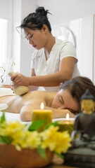 Obraz na płótnie Canvas Young adult woman gets back massage at spa