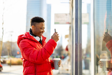 Young man window shopping on city street
