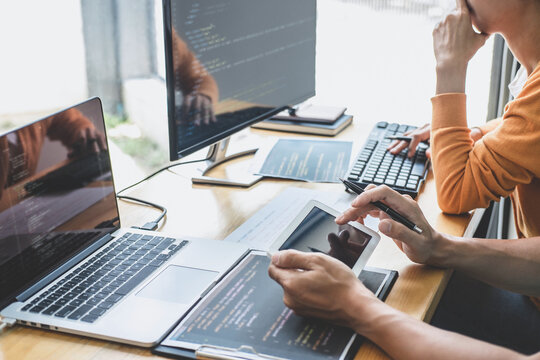 Programmers cooperating at Developing programming and website working in a software develop company office, writing codes and typing data code, Programming with HTML, PHP and javascript