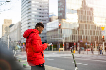 Young man using smart phone outdoors at urban setting

