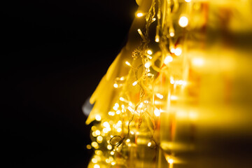 Christmas decoration - garland with yellow light bulbs on street at night - close up. Holiday, celebration, traditional and new year concept