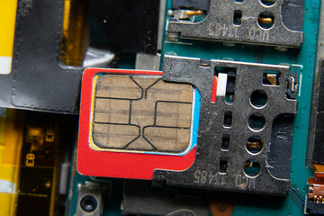 micro sim card inserted into the slot of the disassembled phone close-up