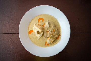 Abkhaz delicious chicken and spice dish with sauce in a white plate on a wooden table