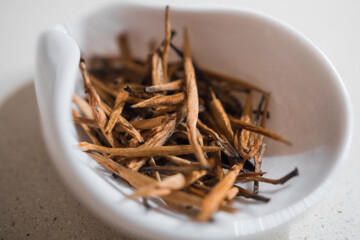 Dian Hong Jin Si. Golden needle (red tea from Yunnan). Beautiful and delicious oxidized tea golden tips leaves in a porcelain container. 