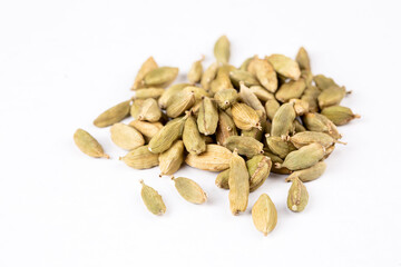 Closeup top view of dried green Elettaria cardamomum fruits with seeds, cardamom spice scattered on white background