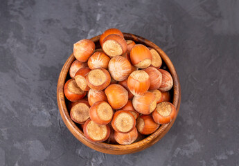 Hazelnut in wooden bowl on black background. Organic hazelnut.