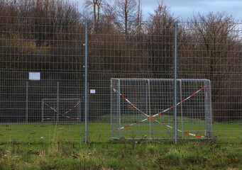 Wegen dem Coronavirus abgesperrter Fußballplatz . Einschränkung durch das Coronavirus.