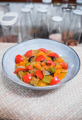 Delicious gastronomic sweet potato curry dish with fresh tomatoes, coconut milk, eggplant, celery and onions. Beautiful professional food presentation. Vertical photography.