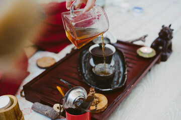 Tea master pours tea on beautiful ceramic dishes. Drink tea according to Chinese customs.