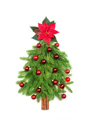 Creative Christmas tree made of fir branches on white isolated background. Red star made from poinsettia flower. The spruce trunk is made from cinnamon sticks.  New Year card. Flat lay.