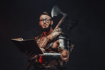 Sad nordic warrior in light armour with fur with eyeglasses and book holding huge axe on his...
