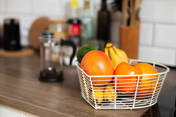 Fresh fruits in metal basket, bowl, bright kitchen, vegeterian food, preparing meal, oranges and...