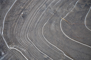 Frozen puddle - abstract circular lines shape this thin layer of frozen ice on a shallow muddy puddle.