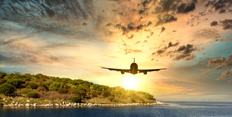 Airplane flying to the beach during sunset