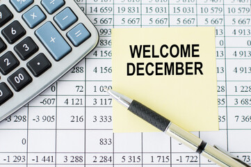 Welcome December inscription on the yellow card on the office table.