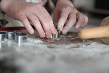 Fototapeta na wymiar Child hands preparing homemade gingerbread cookies. Christmas time in Kitchen. Bakery