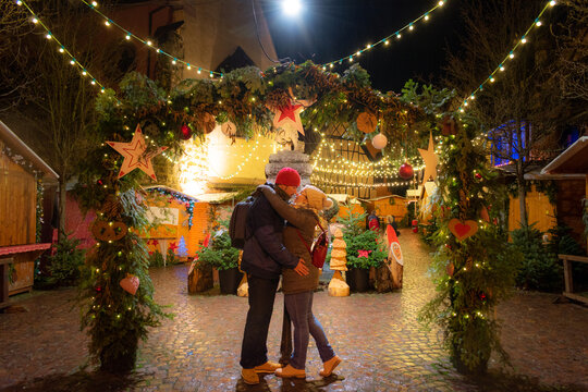 loving couple embracing on a mistletoe at an Alsace Christmas market