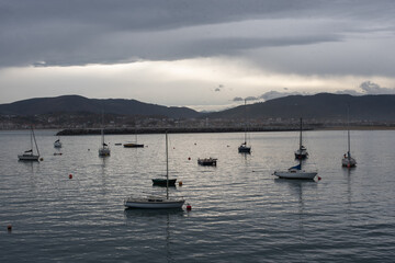 Fototapeta na wymiar barcos varados en el mar amaneciendo en Hondarribia país vasco.