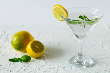 alcohol drinks. Martini glass with cocktail and ice on white background. Cocktail Margarita with lime and green mint on the table. copy space.